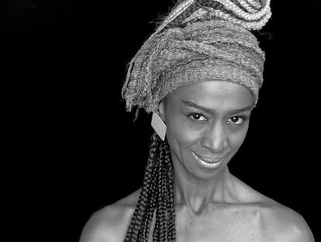 Retrato en blanco y negro de Liz Candelo con turbante y trenzas