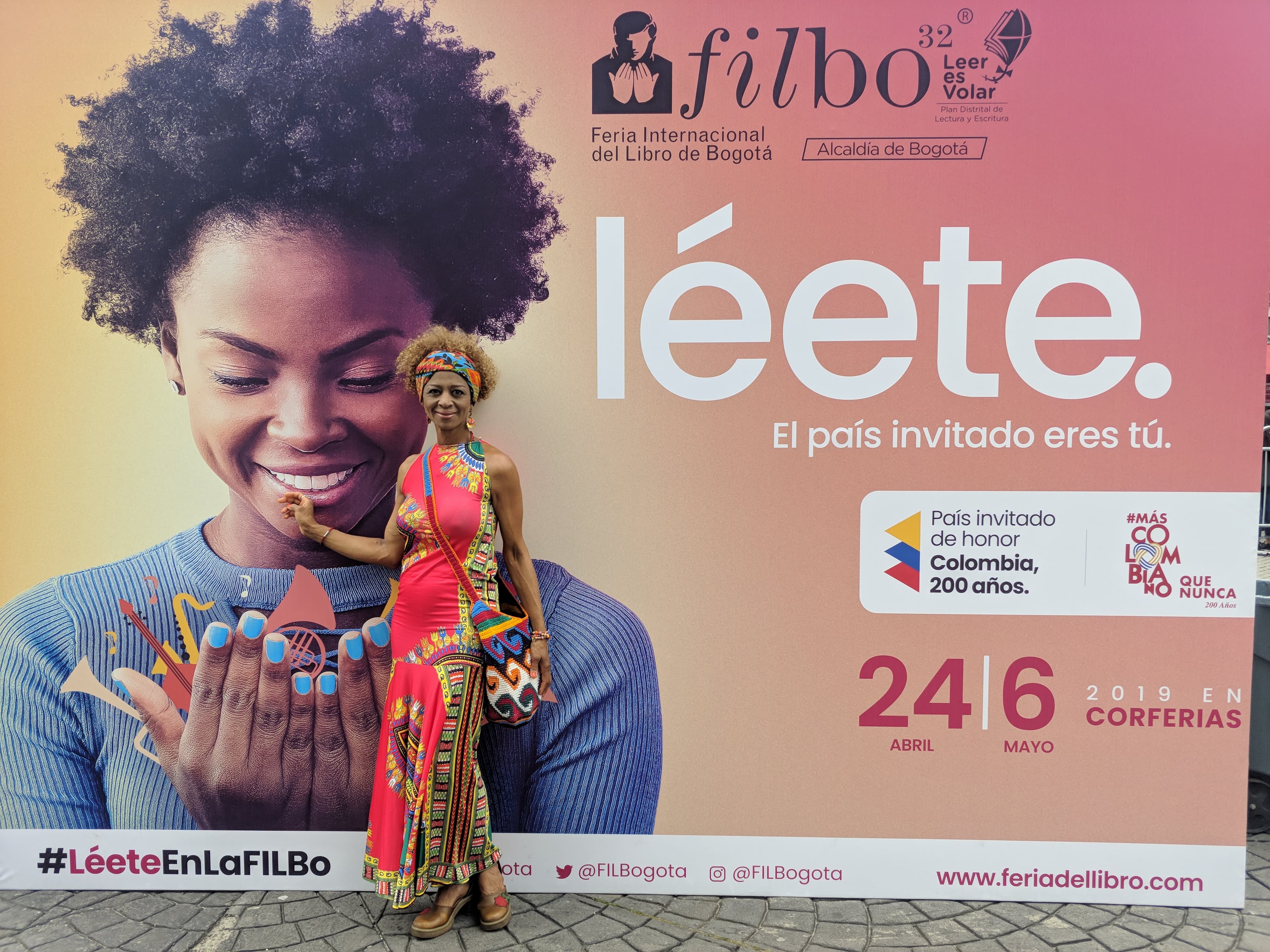 Liz Candelo frente a la pancarta oficial de la 32ª Feria Internacional del Libro de Bogotá, 2019